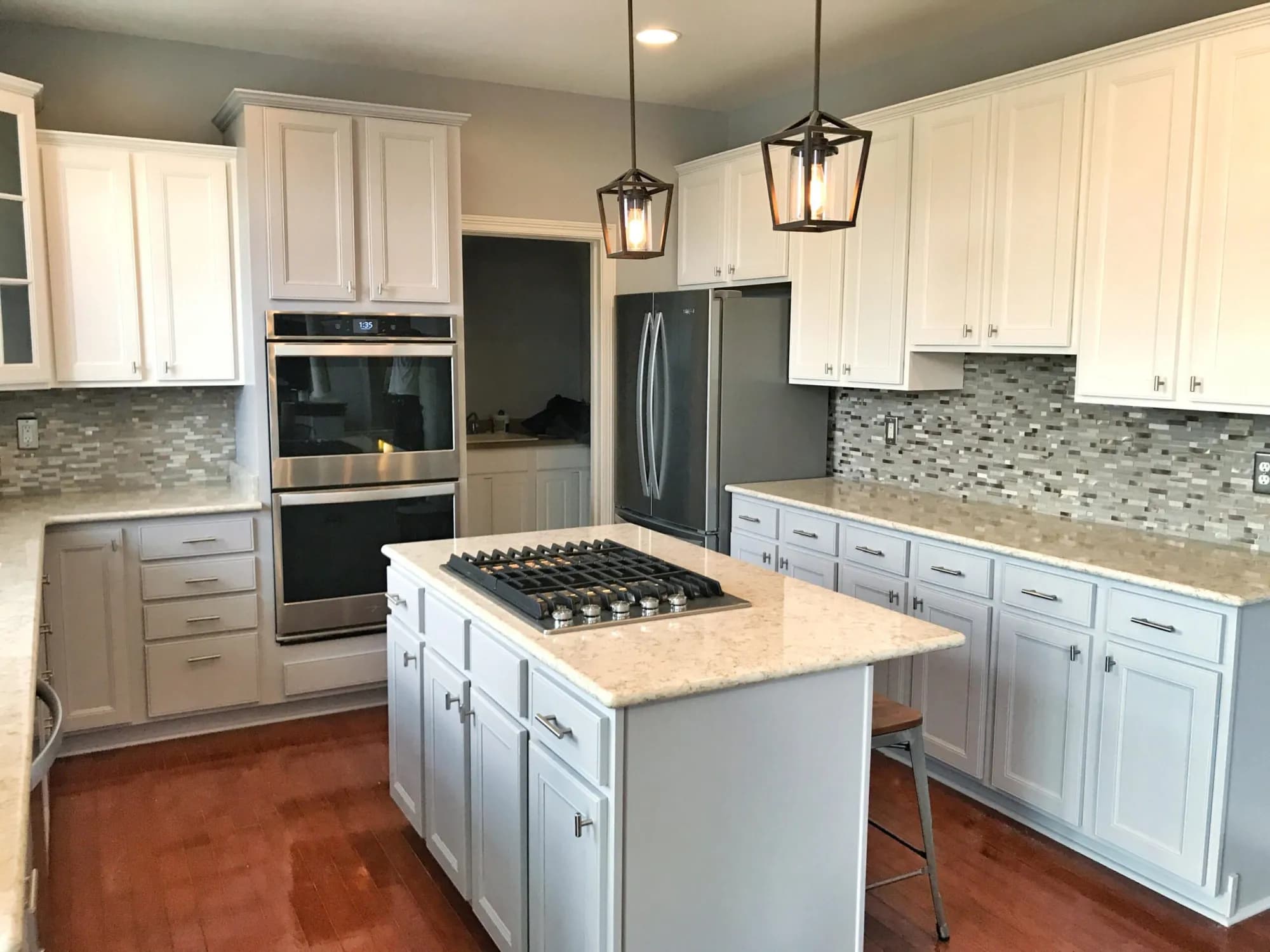 Kitchen cabinets refinished in white by ALL IN Painting