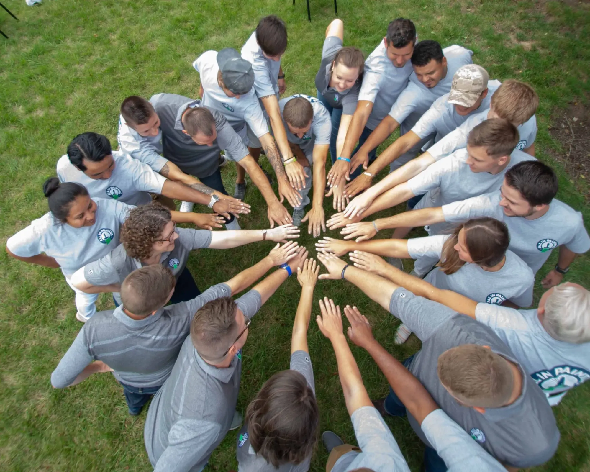 The ALL IN Painting crew stacking hands in a huddle